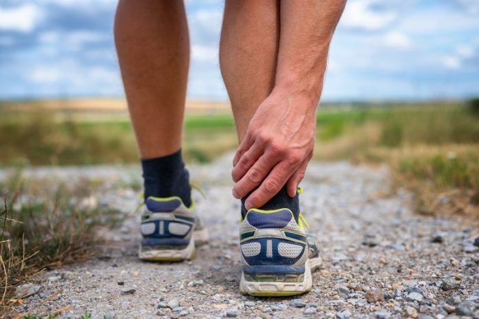 Un homme qui a des douleurs au tendon d'Achille en faisant du sport.