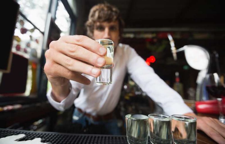 Un barman qui sert de l'alcool à ses clients.