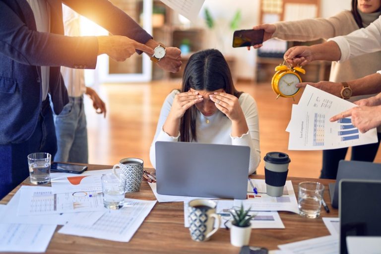 Une femme épuisée, victime du poids de sa charge mentale au travail.