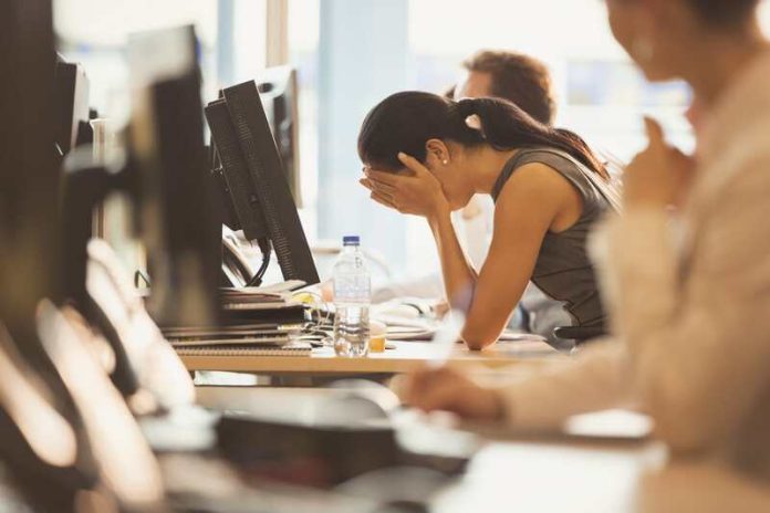 Une femme en situation de stress au travail, fragilisée par l’impact du changement climatique sur son moral, un trouble désormais reconnu sous le nom d’écoanxiété.