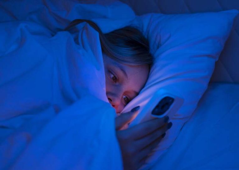 Une femme qui s'endort devant son téléphone pour avoir un bruit de fond.