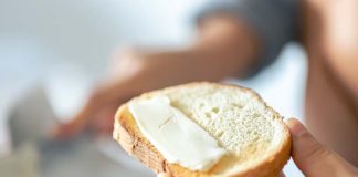Beurre salé ou beurre doux : quel est le meilleur pour la santé ? Une femme qui beurre sa tartine de beurre salé.