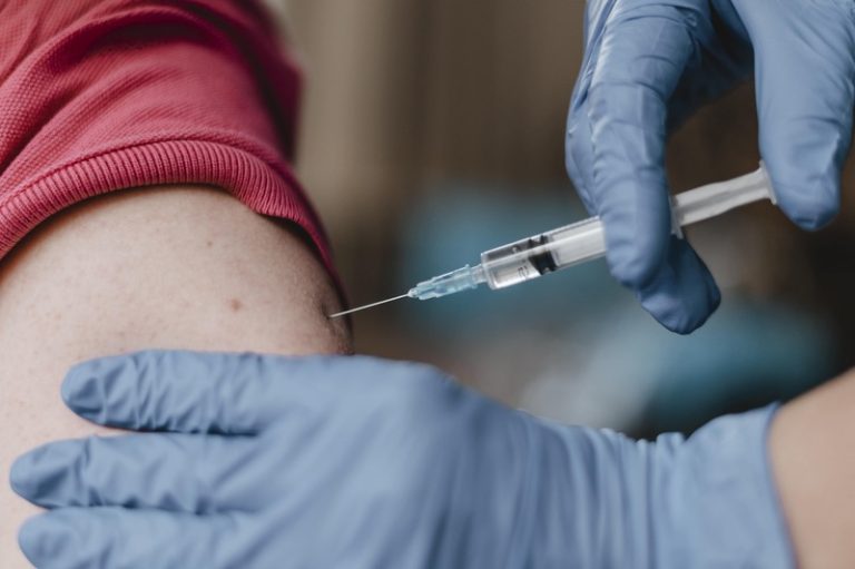 Une personne âgée qui est en train de se faire vacciner pour se protéger de l'épidémie de grippe à venir.