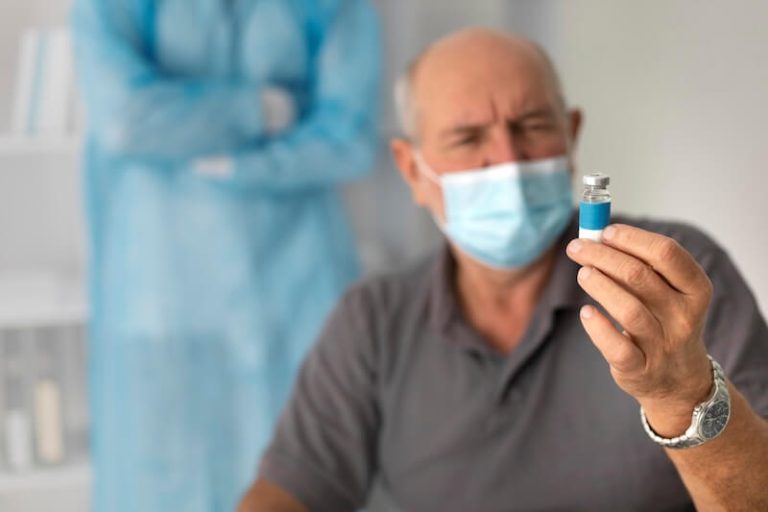 Un patient âgé regarde avec méfiance un vaccin contre le covid ou la grippe.