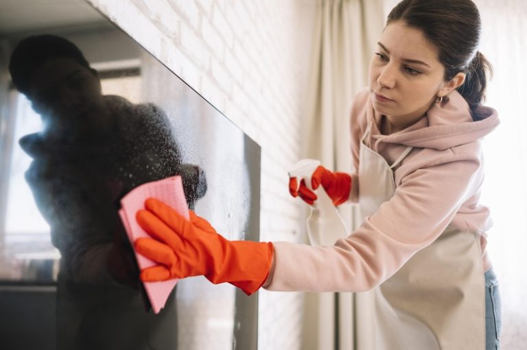 Une femme qui fait un grand ménage pour éliminer les pesticides qui réside dans l'air de son intérieru
