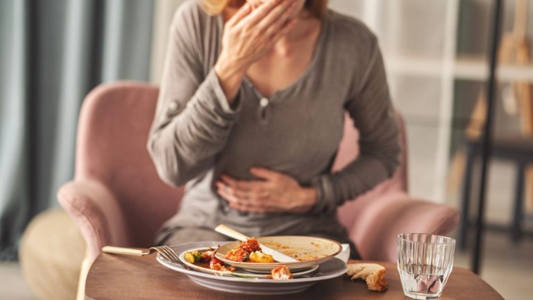 Une femme dont le ventre gargouille parce qu'elle a faim en voyant la nourriture.