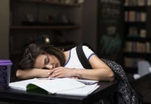 Faut-il retarder le début des cours pour préserver la santé des adolescents ? Une adolescente endormie sur son bureau, épuisée par un début de cours trop matinal.