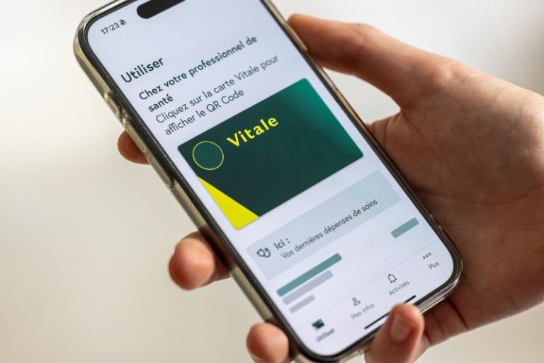 Une femme qui utilise sa carte vitale sur son téléphone.