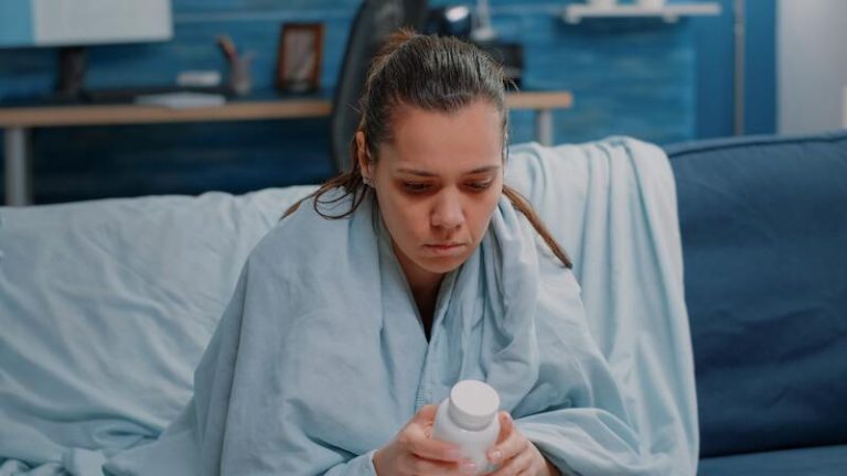 Une femme qui a du mal à dormir et qui hésite à prendre de la mélatonine en gélule.