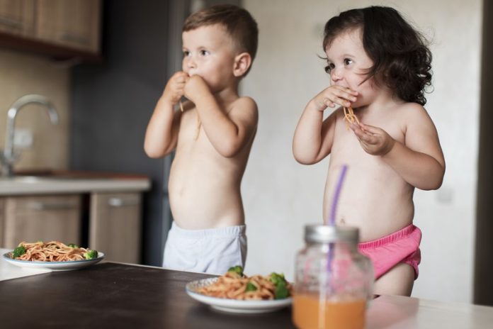 deux enfants qui ne mangent pas de légumes et préfèrent les pâtes.