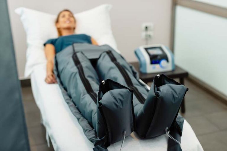 Une femme avec une combinaison pleine d'électrodes, qui teste l'électrostimulation.