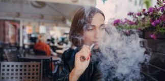 Cigarette électronique : le moyen le plus facile d’en finir avec le tabac ? Une femme qui utilise une cigarette électronique pour arrêter de fumer des cigarettes classiques.