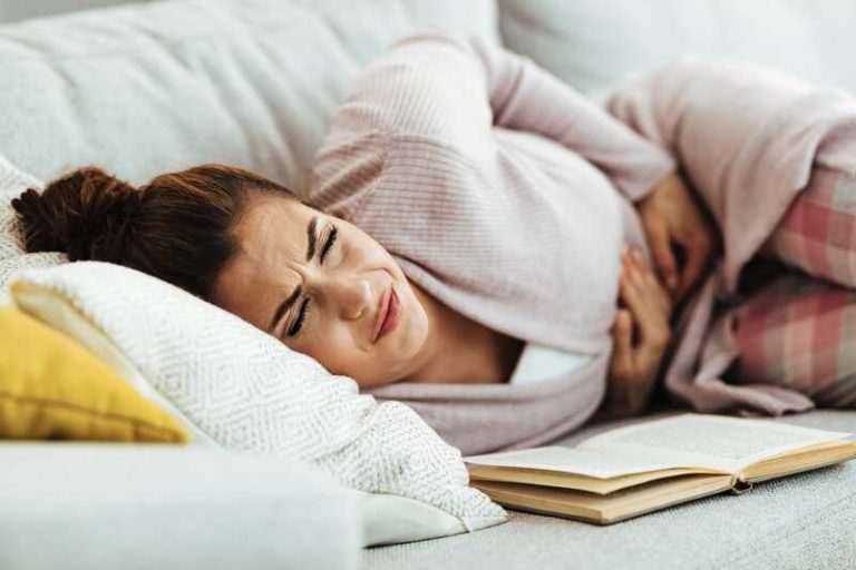Une femme qui a des maux de ventre parce qu'elle a une digestion difficile due à une dyspepsie.
