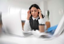 Fatigue mentale : quand l’esprit dit stop ! Une femme derrière son bureau qui souffre de fatigue mentale.