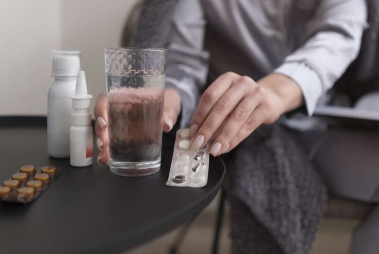 Une femme qui prend du paracétamol à la place des anti-inflammatoires pour soigner une infection hivernale.