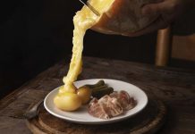 Cholestérol : peut-on quand même manger de la raclette cet hiver ? Une femme qui prépare une raclette pour des personnes souffrant d'un cholestérol.