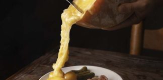 Cholestérol : peut-on quand même manger de la raclette cet hiver ? Une femme qui prépare une raclette pour des personnes souffrant d'un cholestérol.