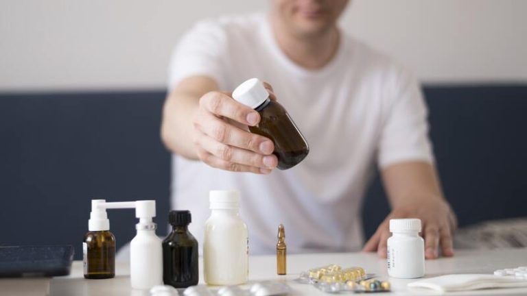 Un homme malade qui hésite entre médicaments et compléments alimentaires pour renforcer son système immunitaire.