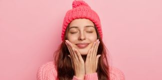 7 conseils pour une routine beauté à moindre frais cet hiver Une jeune femme prenant soin de sa peau par temps froid.