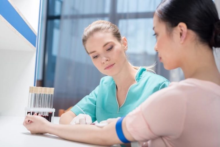 Une jeune femme effectue un test IST avec une biologiste.