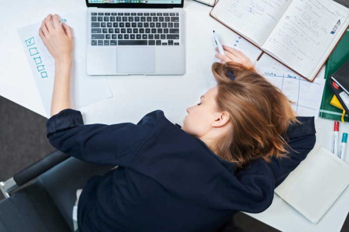 Aller au travail malade quand l’envie de bien faire nuit à la santé Ma Santé Une femme, allongée sur son bureau, qui est allée au travail en étant malade.