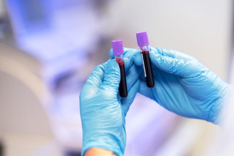 Un médecin réalise une prise de sang chez un patient atteint de Covid-19 afin d’évaluer son risque de développer une forme grave.