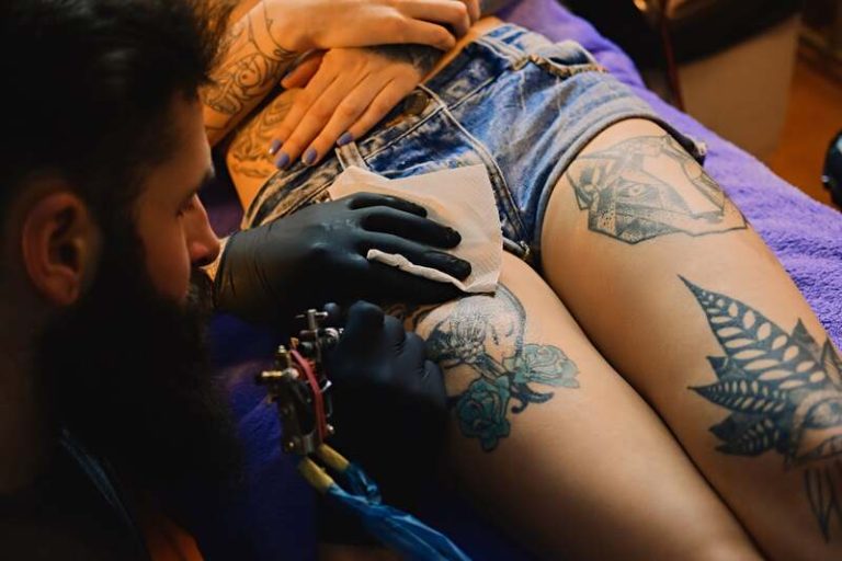 Une femme qui se fait tatouer sans savoir que l'encre peut avoir un impact sur son système immunitaire à long terme.