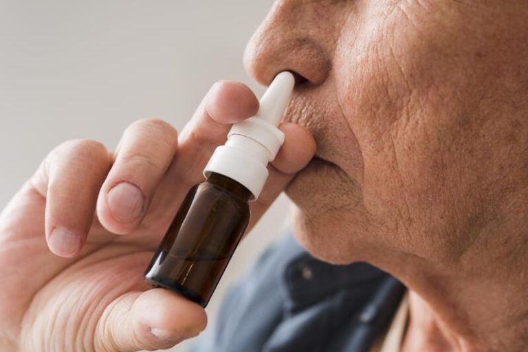 Un homme qui se vaccine contre les infections respiratoires avec un spray nasal.