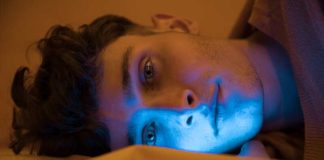 Pensées sombres : pourquoi se réveille-t-on spécifiquement à… 3 h du matin ? Un jeune homme qui se réveille souvent à 3 h du matin et finit sa nuit devant les écrans.