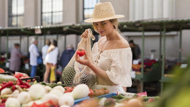 Une femme qui choisit ses fruits et légumes au marché.