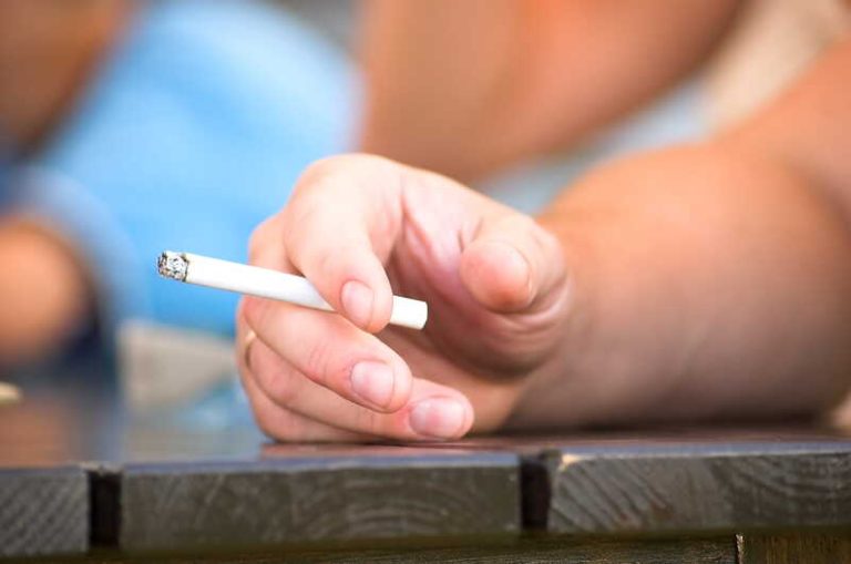 Une personne qui fume sa dernière cigarette, avant la hausse des prix des paquets de cigarettes en mars 2026.