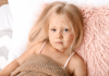 Varicelle : tout savoir sur les symptômes et le traitement des boutons Une petite fille avec des boutons rouges sur le visage suspectant une varicelle