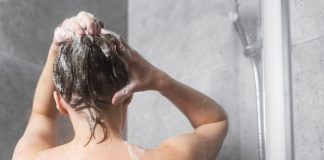 Cheveux : l’erreur fréquente qui dérègle votre cuir chevelu Une femme en train de se laver les cheveux, se demandant à quelle fréquence elle devrait les laver.