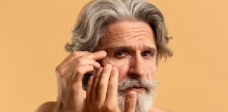 Acide hyaluronique : une substance essentielle pour la peau Un homme se regarde dans le miroir et remarque l’apparition de rides, suspectant un manque d’acide hyaluronique.