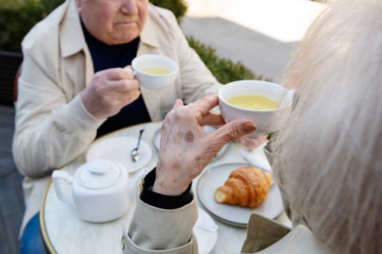 Un couple de personnes âgées qui prennent leur petit-déjeuner tardivement.