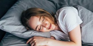 Avant de dormir : 6 habitudes qui pourraient vous rendre plus heureux Une femme qui se couche après avoir accompli sa routine du soir pour être plus heureuse.