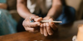 Cannabis et santé mentale : un faux remède qui peut aggraver les troubles Un jeune homme qui roule et fume un joint de cannabis.