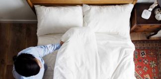 Hygiène du quotidien : à quelle fréquence faut-il vraiment laver ses draps ? Un homme qui vient de changer ses draps pour laver sa housse de couette, son drap-housse et ses taies d’oreiller.