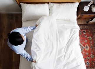 Hygiène du quotidien : à quelle fréquence faut-il vraiment laver ses draps ? Un homme qui vient de changer ses draps pour laver sa housse de couette, son drap-housse et ses taies d’oreiller.