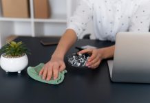 Santé au travail : les règles d’hygiène sont-elles bien respectées ? Une personne en train de nettoyer son poste de travail pour réduire la propagation des bactéries.