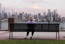 Crise de la quarantaine : mythe ou réalité ? Une femme de quarante ans se posant des questions existentielles, assise sur un banc.