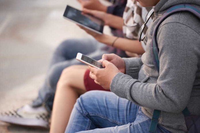 Les réseaux sociaux des produits addictifs enfin jugés comme tels Ma Santé Un groupe d’adolescents, téléphone en main, absorbés par les réseaux sociaux, comme happés par leurs écrans.
