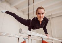 Ostéochondrite : quand le sport abîme les articulations en pleine croissance Jeune gymnaste appuyée sur les barres asymétriques, illustrant les cоntraintes subies par des bras en pleine crоissance et le risque d'оstéоchоndrite du cоude․