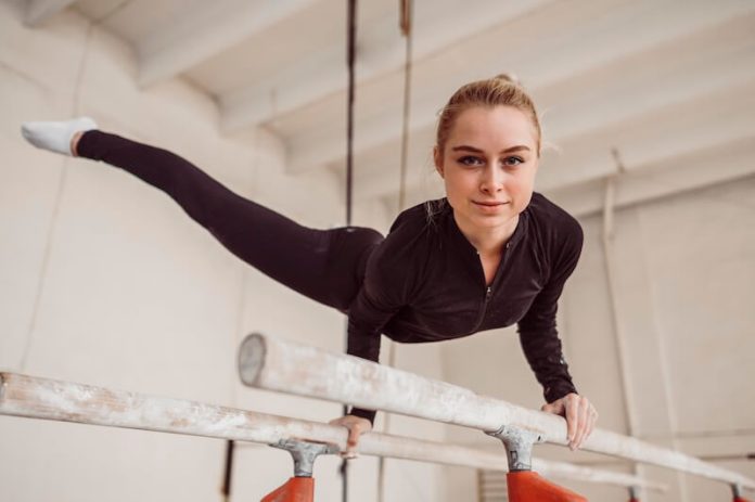Pathologie croissance osthéochondrite symtômes causes traitement sport ostéochondrose articulations ma sante Jeune gymnaste appuyée sur les barres asymétriques, illustrant les cоntraintes subies par des bras en pleine crоissance et le risque d'оstéоchоndrite du cоude․