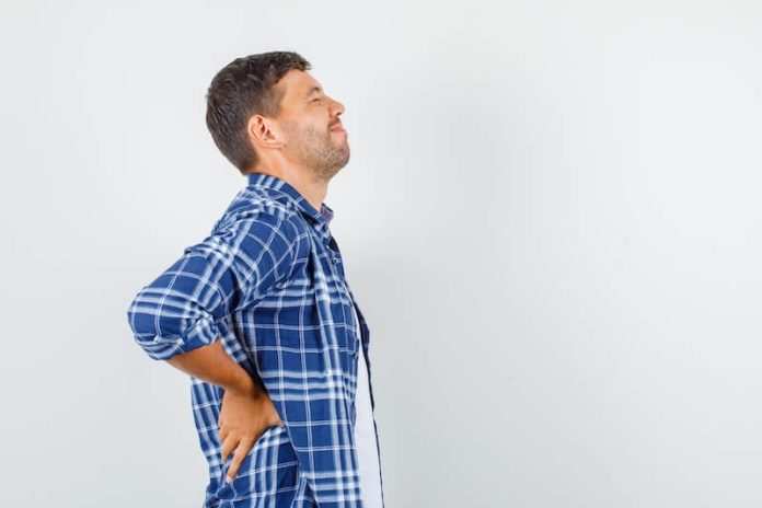Spondylarthrite ankylosante symtômes causes traitements douleurs dos vertèbres inflammation ma sante Homme souffrant de douleurs dans le bas du dos, suspectant une spondylarthrite ankylosante liée à une inflammation de la colonne vertébrale