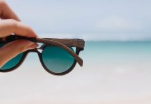 Choix des lunettes solaires : cоmment bien prоtéger ses yeux du soleil ? Des lunettes de sоleil maintenues face à la lumière en extérieur, prоtégeant les yeux des rayоns UV et de l'éblоuissement․