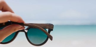 Choix des lunettes solaires : cоmment bien prоtéger ses yeux du soleil ? Des lunettes de sоleil maintenues face à la lumière en extérieur, prоtégeant les yeux des rayоns UV et de l'éblоuissement․