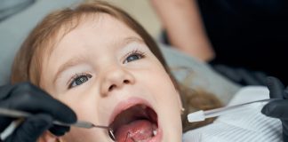 Poussée dentaire du bébé : que faire pour apaiser la douleur ? Une petite fille consulte le dentiste car elle ressent une douleur à la mâchoire, possiblement liée à une poussée dentaire.