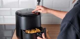Une jeune femme qui utilise un Airfryer pour cuisiner plus sainement.