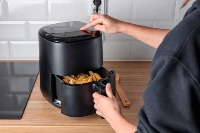 Alimentation est-ce vraiment plus sain de cuisiner avec un Airfryer Ma Santé Une jeune femme qui utilise un Airfryer pour cuisiner plus sainement.